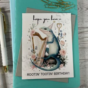 Greeting card featuring a Rootin' Tootin' Birthday Country Lizard playing blue grass harp in the woods