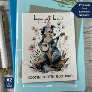 Greeting card featuring a Rootin' Tootin' Birthday Country Dog playing blue grass banjo in the woods