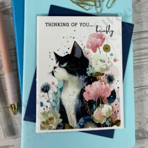 Greeting card featuring a passive aggressive cat with message "thinking of you... briefly"