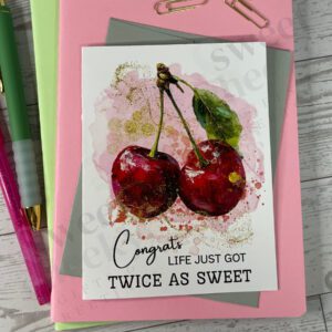 greeting card featuring 2 cherry fruits attached at the stem with the message for new parents "congrats life just got twice as sweet"
