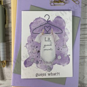 Cute lavender new baby greeting card announcement featuring onsie with text "hello grandparents" and below "guess what?!"